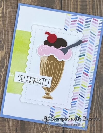 Share a Milkshake card with blue base, some multi-color stripes and a big chocolate sundae dish with pink ice cream, chocolate fudge and a cherry