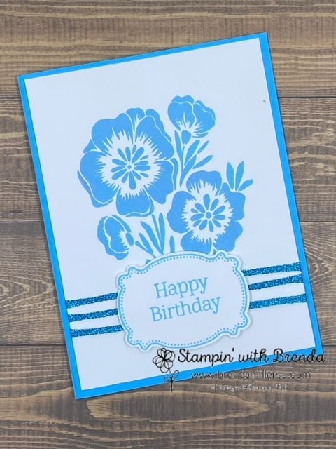 Card with large flower image from Lasting & Lovely with 3 ribbons across the bottom and a Happy Birthday sentiment on a Lasting Label punch all in Tranquil Tide