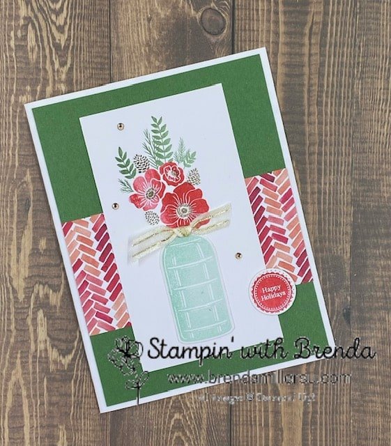 White and green Vintage Christmas card with Painted Christmas DSP, red flowers, green leaves and brown pinecones plus a glossy bottle with a happy holidays sentiment