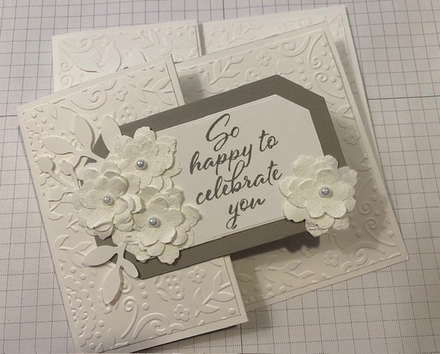 white wedding card with white flowers and white dry embossed background. Greeting is so happy to celebrate you